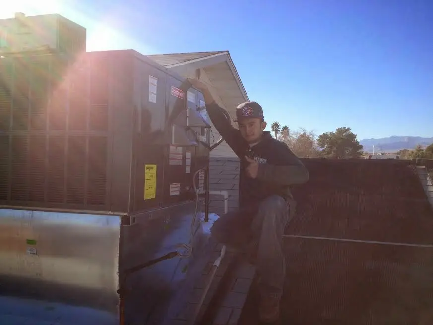 HVAC technician performing Air Duct Repair on a rooftop unit in Litchfield